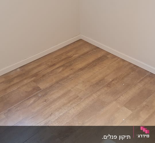 רצפת פרקט עץ בחדר ריק עם קירות בהירים